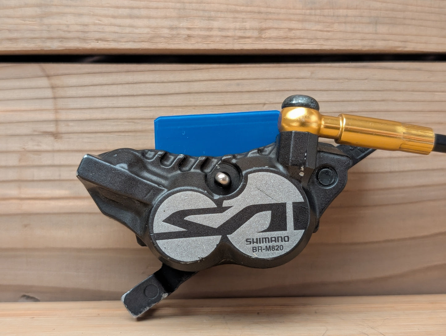 Shimano BR-M820 bicycle brake lever on a wooden background