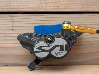 Shimano BR-M820 bicycle brake lever on a wooden background